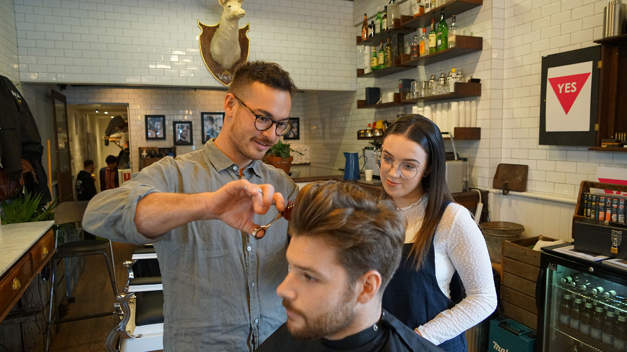 Male teacher with Female student cutting hair                       