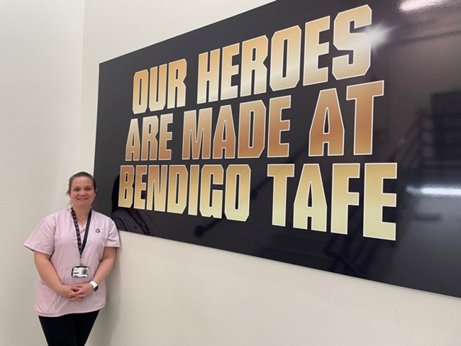 student standing in front of heroes sign