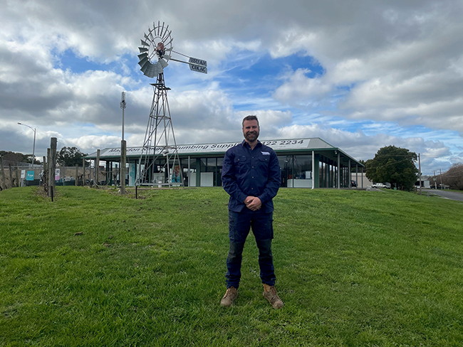 student standing in front on windmill