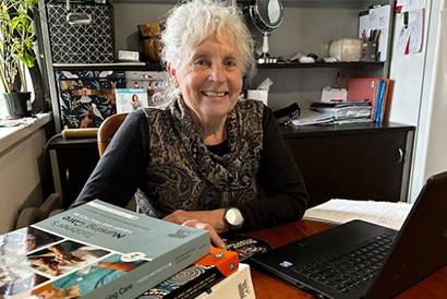 Student Julie Loomes sitting as her desk smiling