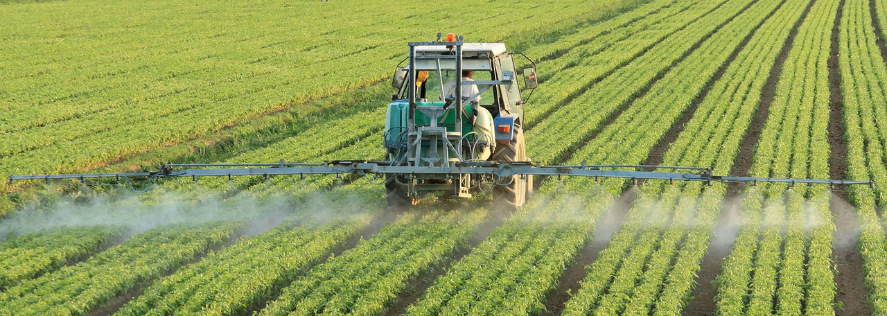 A modern hi-tech tractor spraying a field of crops